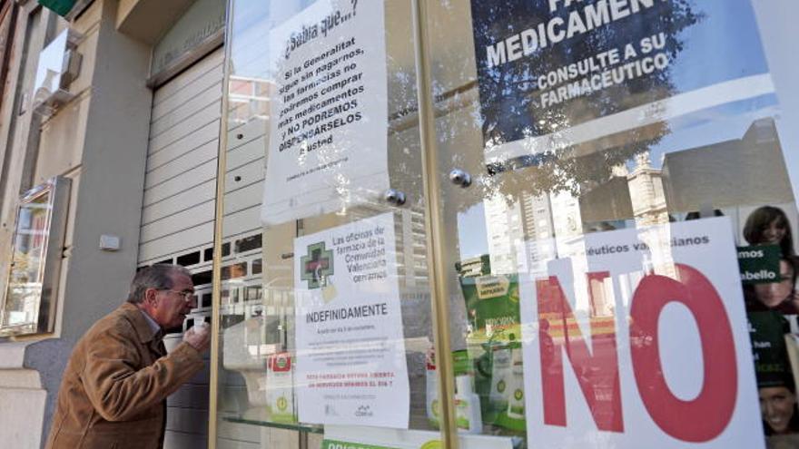 Un hombre observa el interior de una farmacia cerrada en seguimiento de la huelga indefinida.