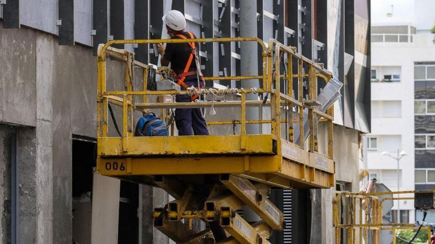 Un trabajador coloca la estructura de una fachada en la capital.