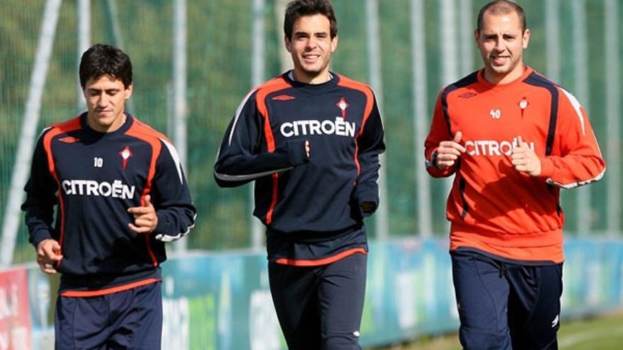 Borja Oubiña (centro) trota sobre el césped de a Madroa junto a Canobbio y uno de los recuperadores del Celta.