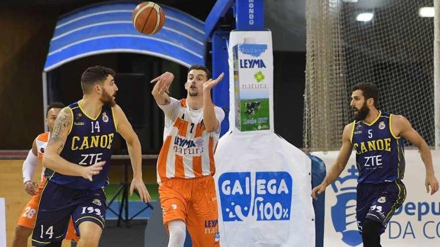 Sergi Pino, entre dos jugadores del Canoe en el último partido del Leyma en el Palacio.