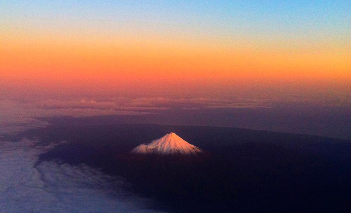 La muntanya Taranaki, a Nova Zelanda, mostra al cim una llum especial a causa del núvol de cendra procedent d’un volcà xilè que travessa el Pacífic.