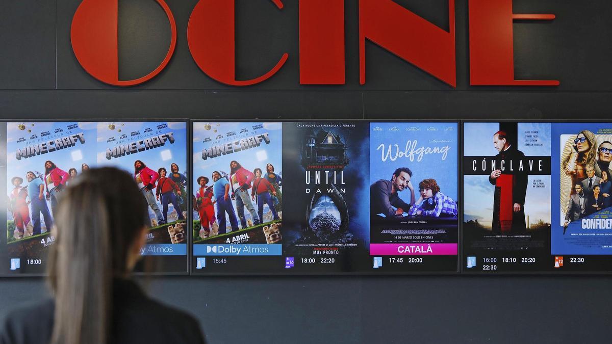 Una espectadora observa la cartellera d'un cinema en una imatge d'arxiu