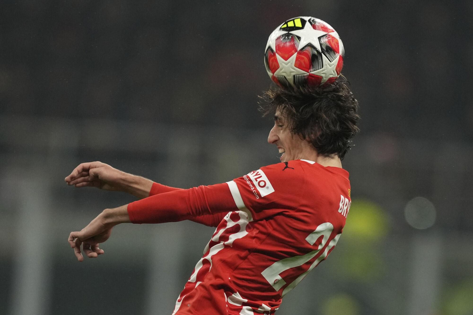 Girona's Bryan Gil heads the ball during the Champions League opening phase soccer match between AC Milan and Girona at the San Siro stadium in Milan, Italy, Wednesday, Jan. 22, 2025. (AP Photo/Antonio Calanni). EDITORIAL USE ONLY/ONLY ITALY AND SPAIN