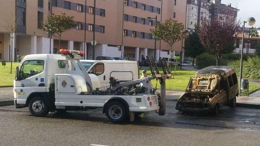 La grúa municipal procediendo ayer a retirar el último de los cinco vehículos calcinados.