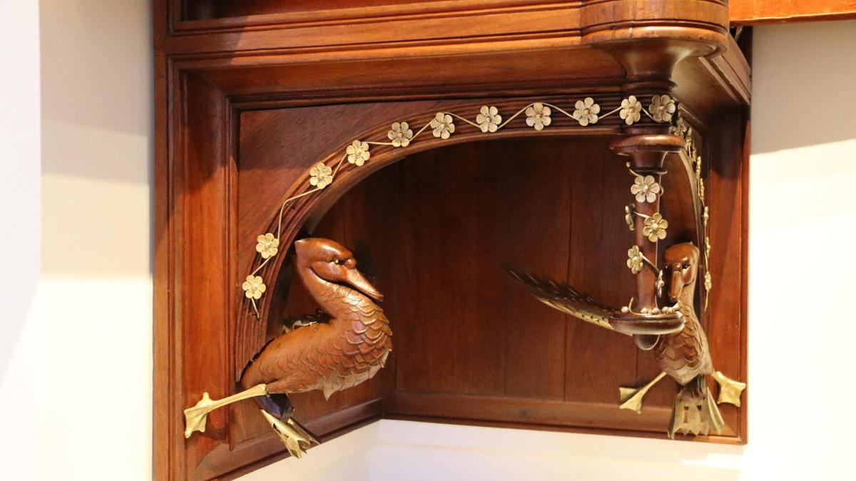 Els ocells de fusta tallada i llautó calat, situats a la part exterior del moble.