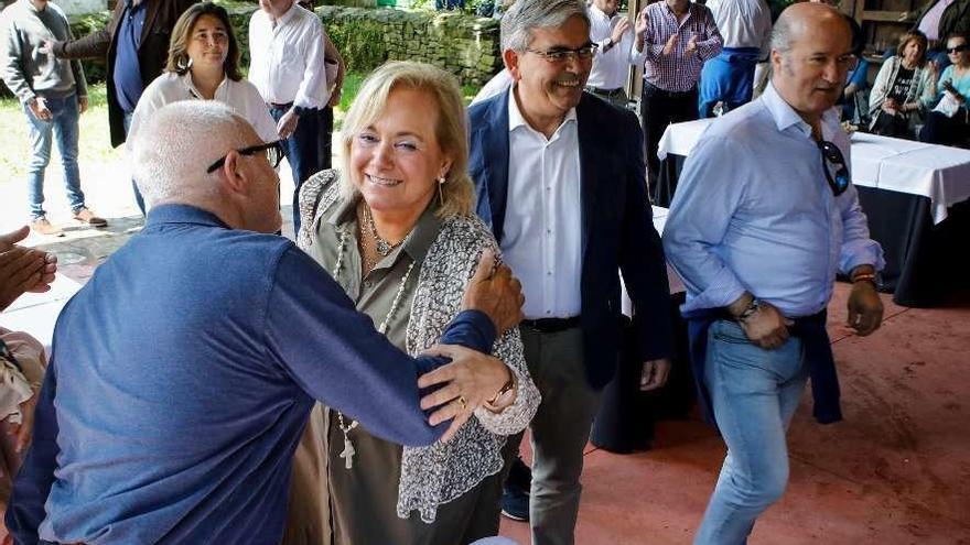 Mercedes Fernández saluda a un militante en la espicha del PP de Gijón, ayer, en el Pueblo de Asturias, acompañada de Mariano Marín y Luis Venta Cueli.