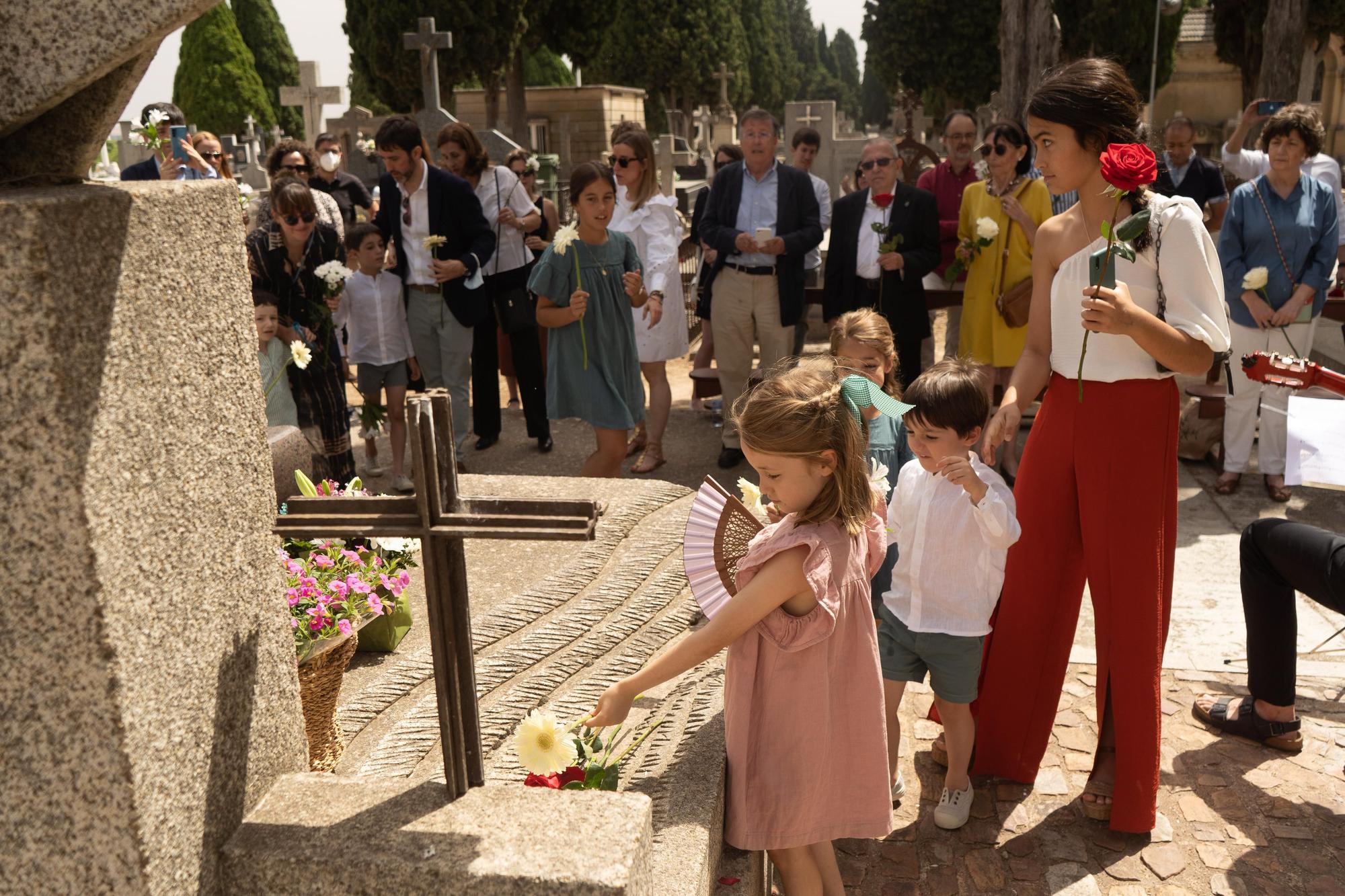 Los sobrinos nietos de Clara Miranda depositan flores en la sepultura de sus dos seres queridos; a la izquierda, un integrante del Seminario Claudio Rodríguez lee un poema.| J.L.F