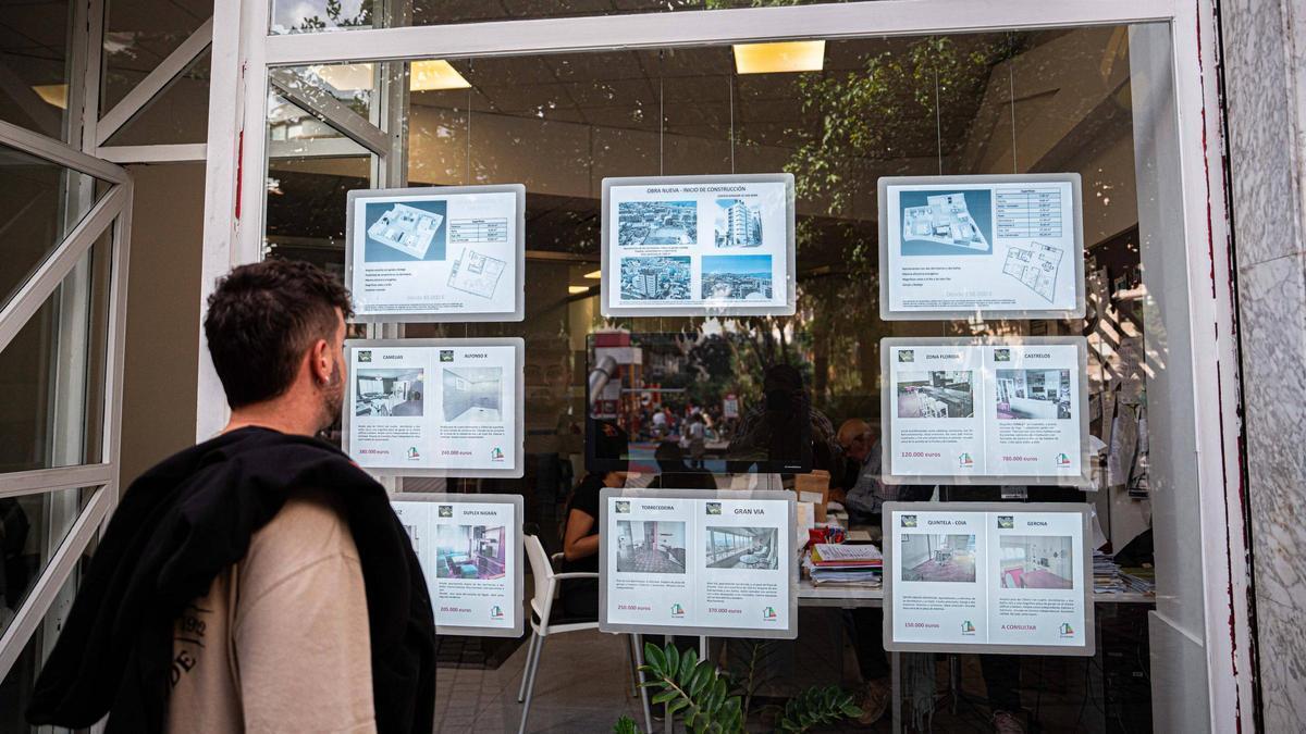 Un joven observa el escaparate de una inmobiliaria en Vigo.