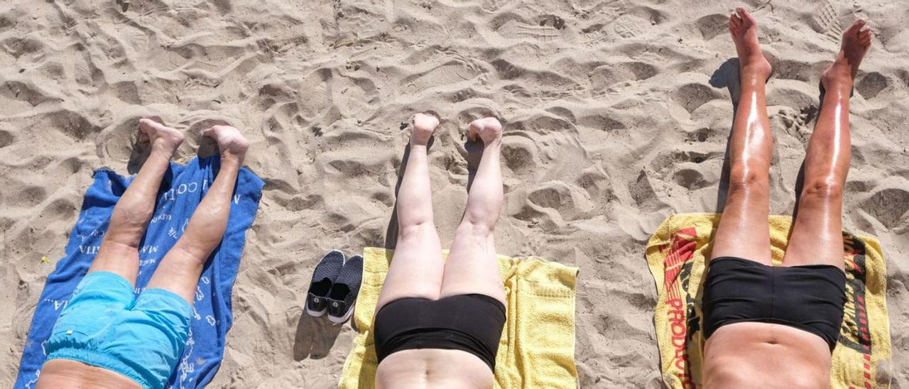 Turistas jubilados toman ayer el sol en la playa de Levante de Benidorm. | ÁXEL ÁLVAREZ