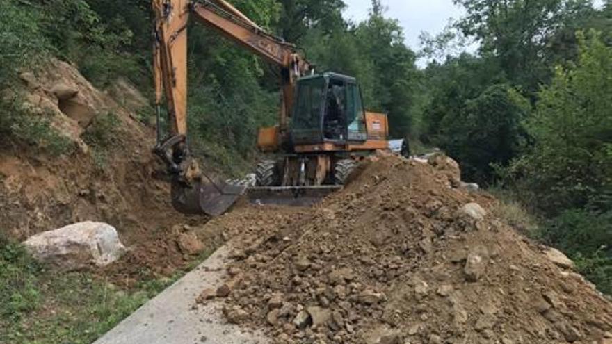 Una màquina excavadora repara un despreniment.