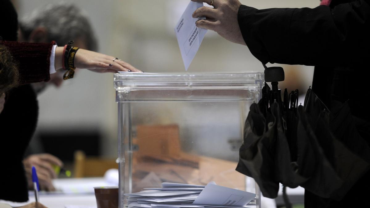 Una persona deposita su voto en una urna.