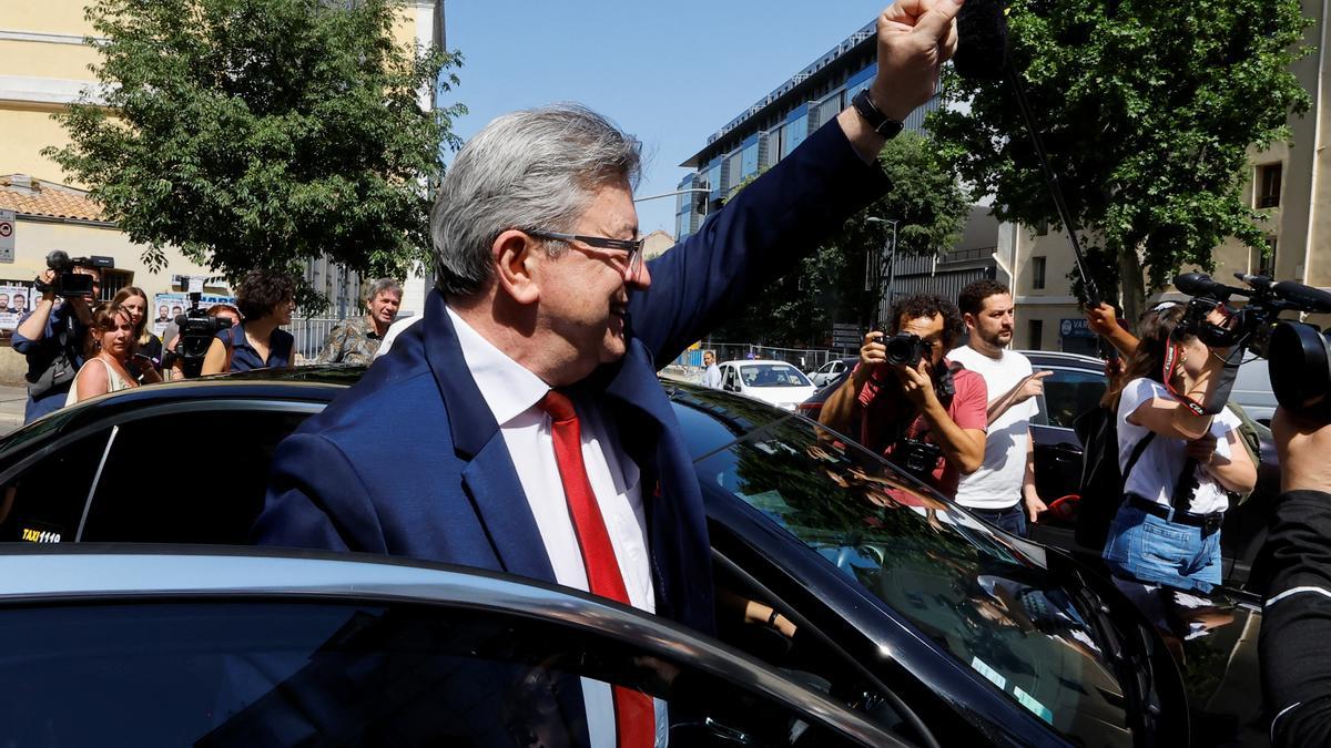 El líder de la Francia Insumisa, Jean-Luc Mélenchon, alza el brazo tras votar en un colegio electoral de Marsella, este domingo.