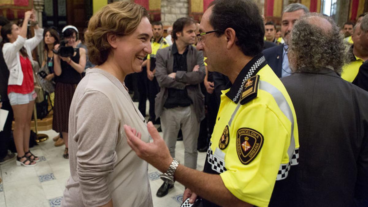 Ada Colau conversa con el jefe de la Guardia Urbana de Barcelona, Evelio Vázquez, en un acto en el Saló de Cent del ayuntamiento.