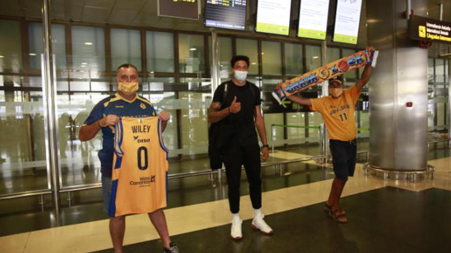 Jacob Wiley, a su llegada al Aeropuerto de Gran Canaria, junto a dos aficionados del Granca