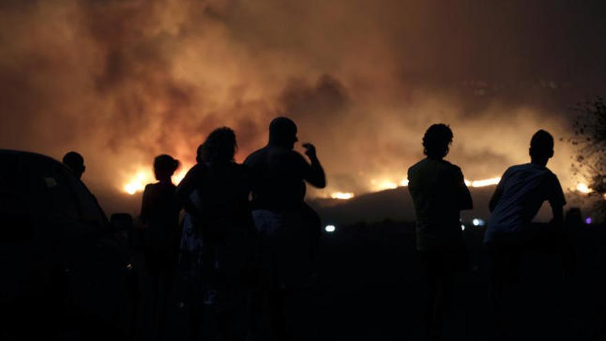 Vecinos de la localidad malagueña de Mijas, observan el incendio forestal declarado sobre las 20.30 horas de esta noche en el paraje de Entrerríos, obligando al desalojo preventivo de un centro de drogodependencia.