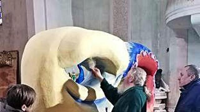 Miembros de la asociación pintan la máscara de carnaval.