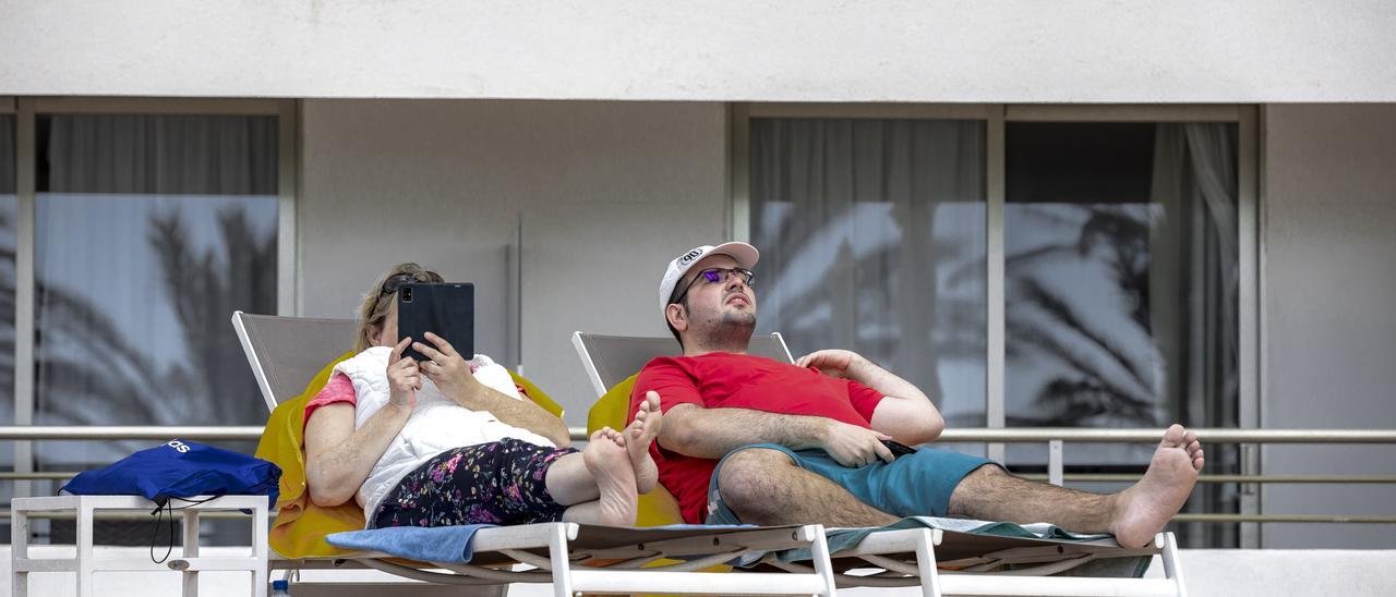 Turistas alemanes toman el sol en la terraza de un hotel de la Playa de Palma