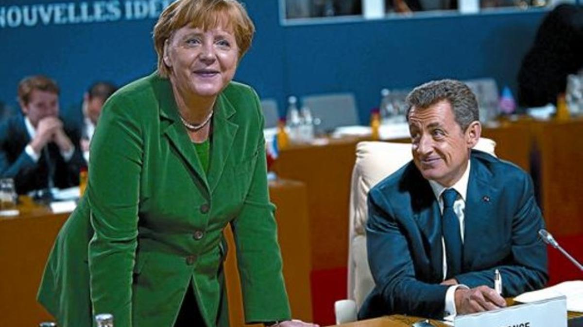 Angela Merkel y Nicolás Sarkozy en un momento de descanso durante la cumbre de Cannes, ayer.