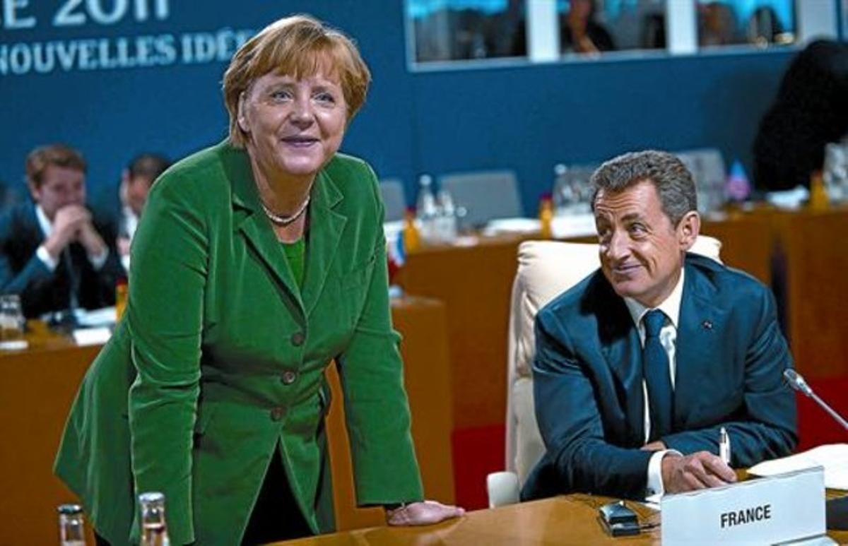 Angela Merkel i Nicolás Sarkozy en un moment de descans durant la cimera de Cannes, ahir.