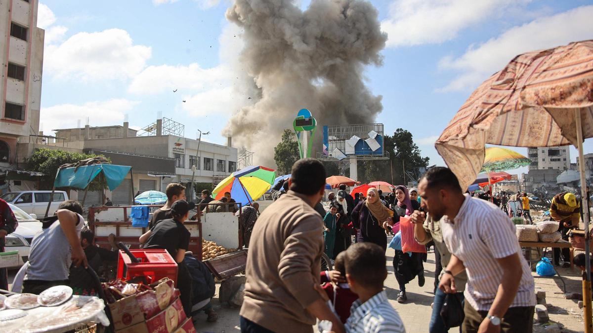 Ciudadanos palestinos observan una columna de humo durante un bombardeo de Israel en el mercado de Firas, en Ciudad de Gaza, el 11 de abril del 2024