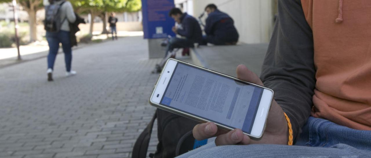 Un estudiante muestra un documento pdf en la pantalla de un teléfono móvil, uno de los métodos más empleados ahora para copiar.