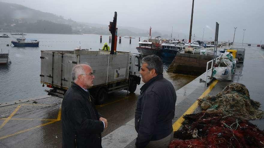 Durán y el patrón mayor de Aldán, ayer en el muelle inspeccionando la operación de limpieza // G. Núñez