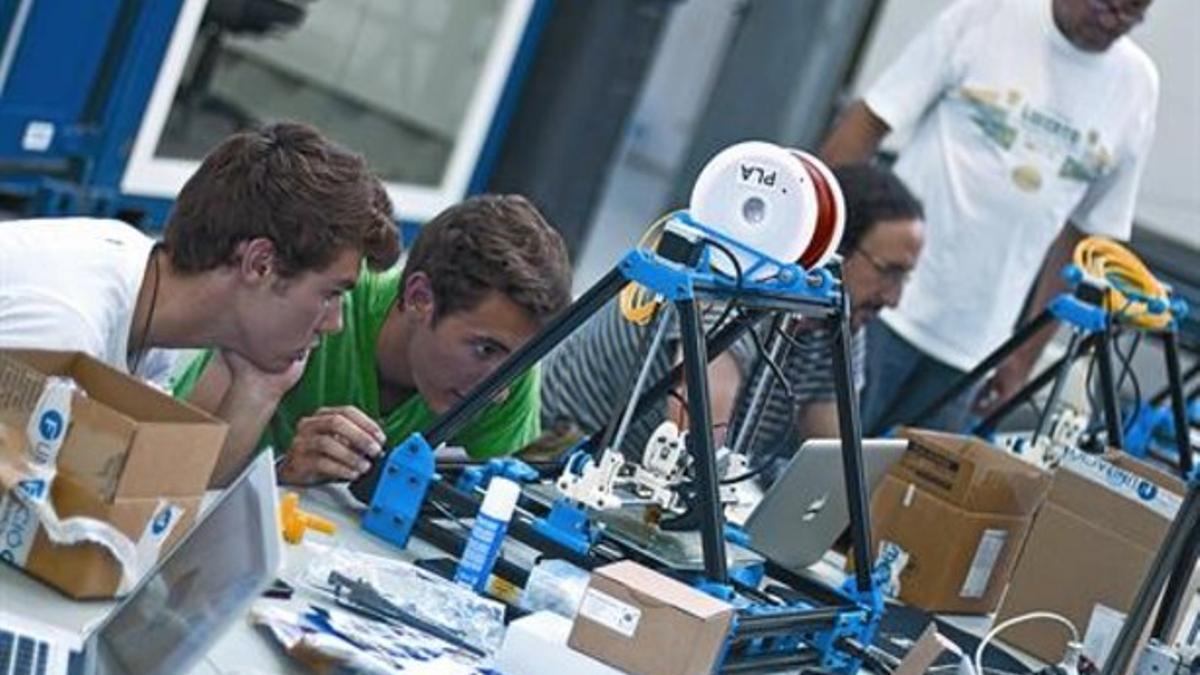 Prototipos 8 Tres participantes en el taller de Les Corts observan la impresión de las máquinas, el viernes.