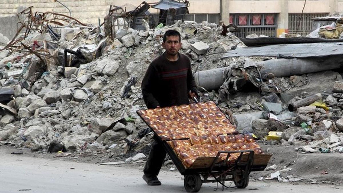Un ciudadano de Alepo recoge escombros.
