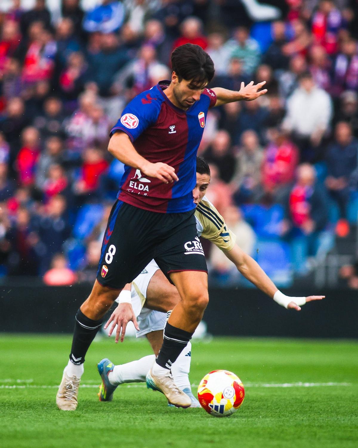 Bustillo conduce el balón durante el partido contra el Marbella