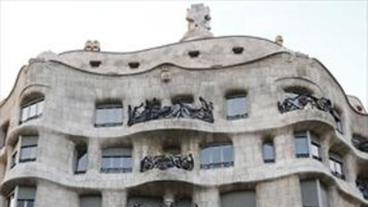 Una turista fotografía la Pedrera de Gaudí, cuya fachada está registrada como marca.