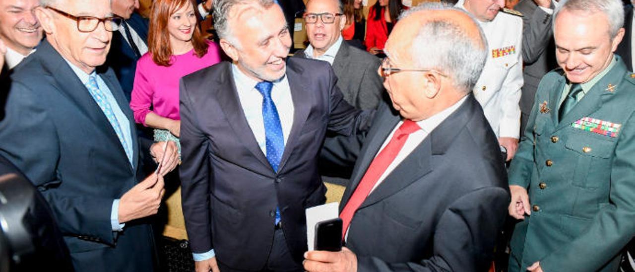 Ángel Víctor Torres (izquierda) y Casimiro Curbelo se saludan en el Día de Canarias. Detrás, José Miguel Barragán.