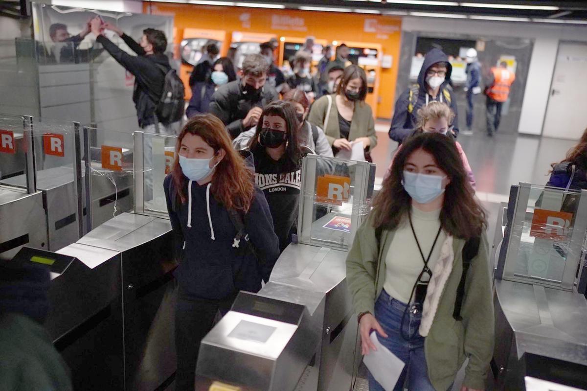 Un grupo de jóvenes pasan sin pagar en la estación de Arc de Triomf de Barcelona para denunciar la grave situación que vive Renfe.