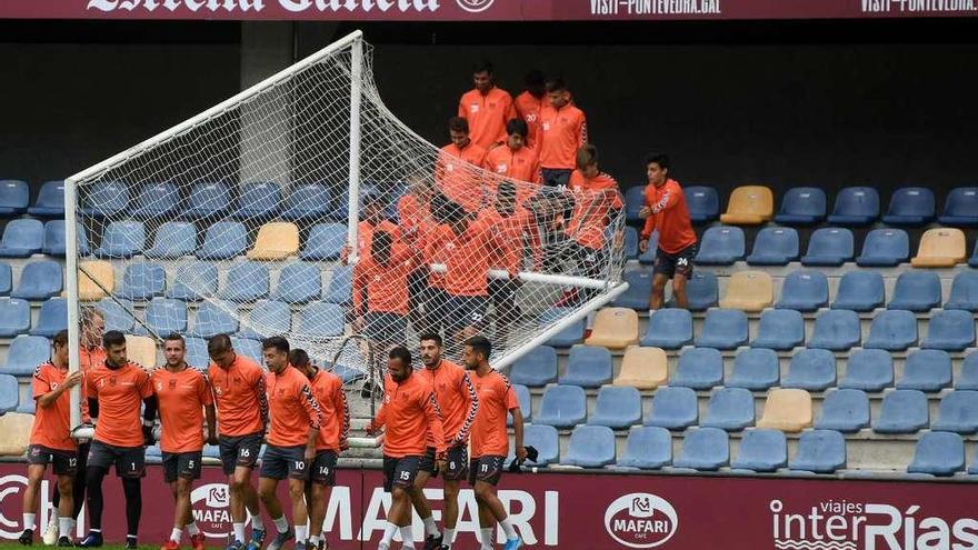 Los jugadores del Pontevedra transportan una portería para realizar un ejercicio en un entrenamiento en Pasarón. // Gustavo Santos