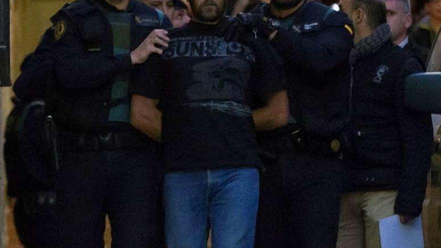 Dos guardias trasladan, ayer, al presunto autor del triple crimen. // Efe