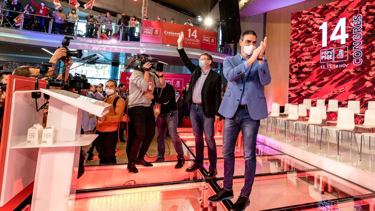 Ximo Puig y Pedro Sánchez aplauden en el escenario del congreso de Benidorm antes de comenzar el acto de clausura, ayer.  | DAVID REVENGA