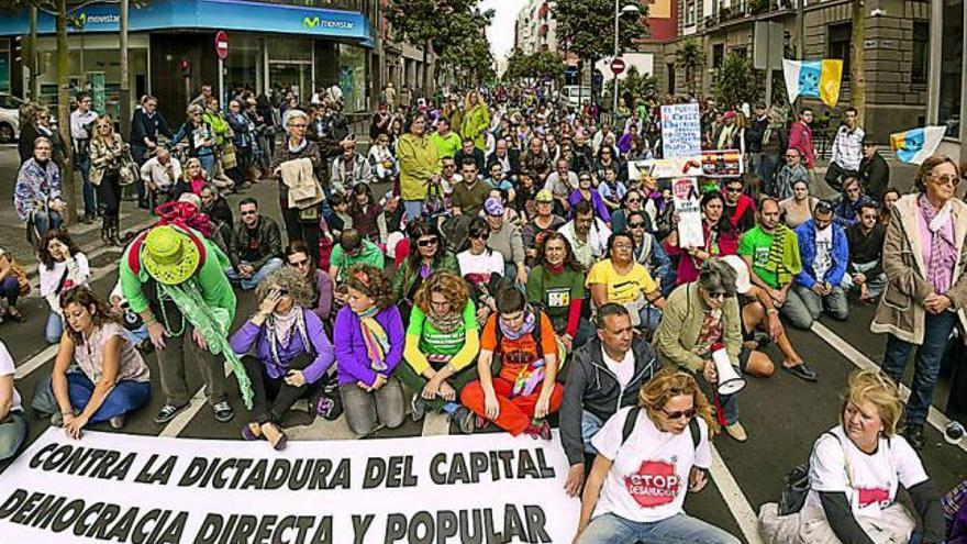 Cientos de ciudadanos se sentaron varios minutos ante el Banco de España durante la protesta en la capital grancanaria. | efe