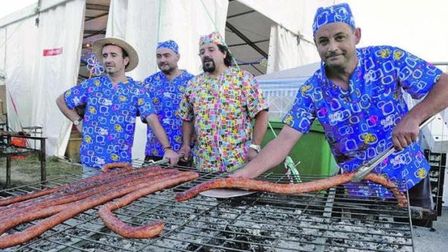 Antonio Blázquez, Ángel Gómez, Antonio Riopedre y Emilio Barredo, parrilleros de la empresa Oscos, cortando el «superchorizo».