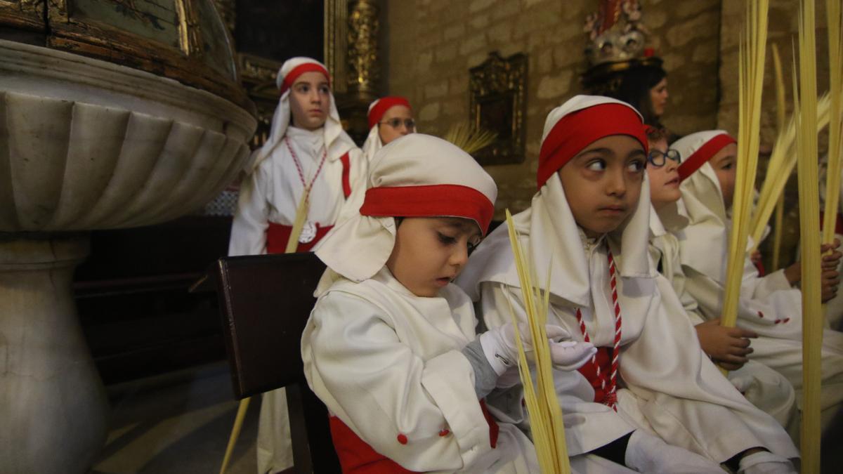 Grupo de niños del cortejo de La Borriquita con la tradicional palma en la mano.