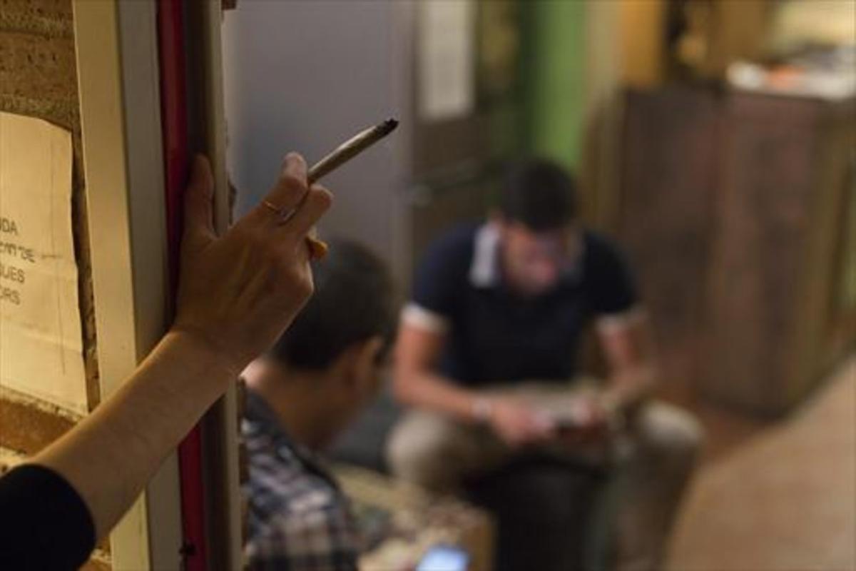 Una mujer consume un porro en un club cannábico de Ciutat Vella. Una mujer consume un porro en un club cannábico de Ciutat Vella.