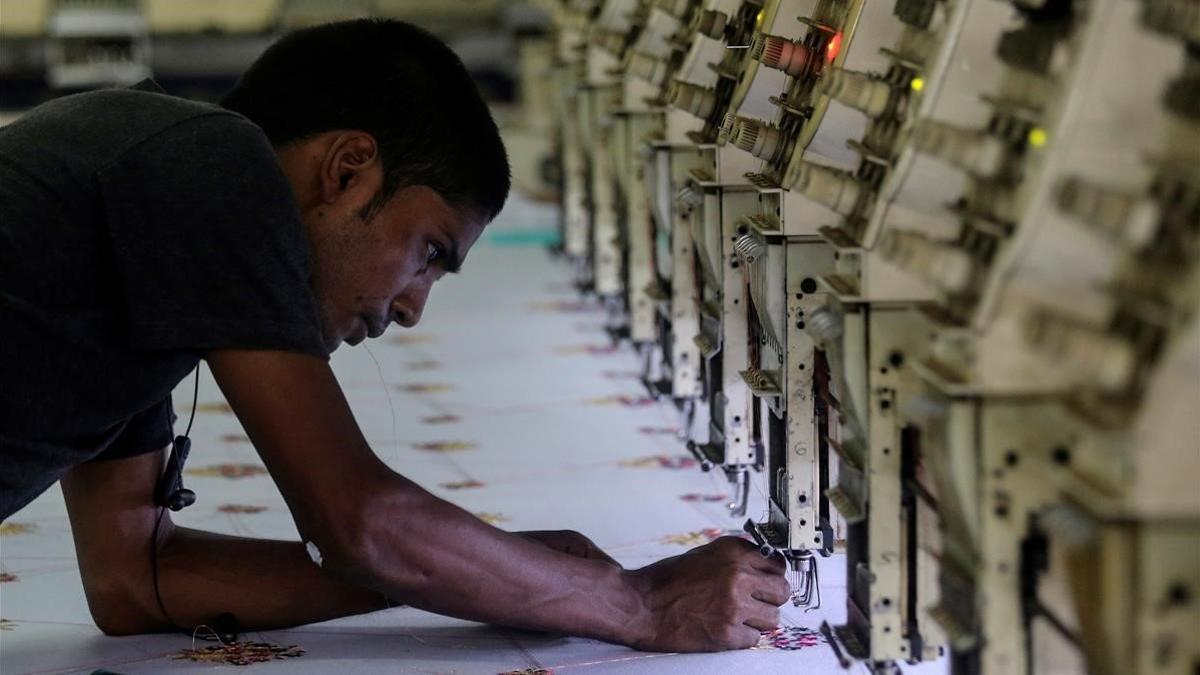 zentauroepp48407913 a worker adjusts the thread on an embroidery machine at a wo190601093319