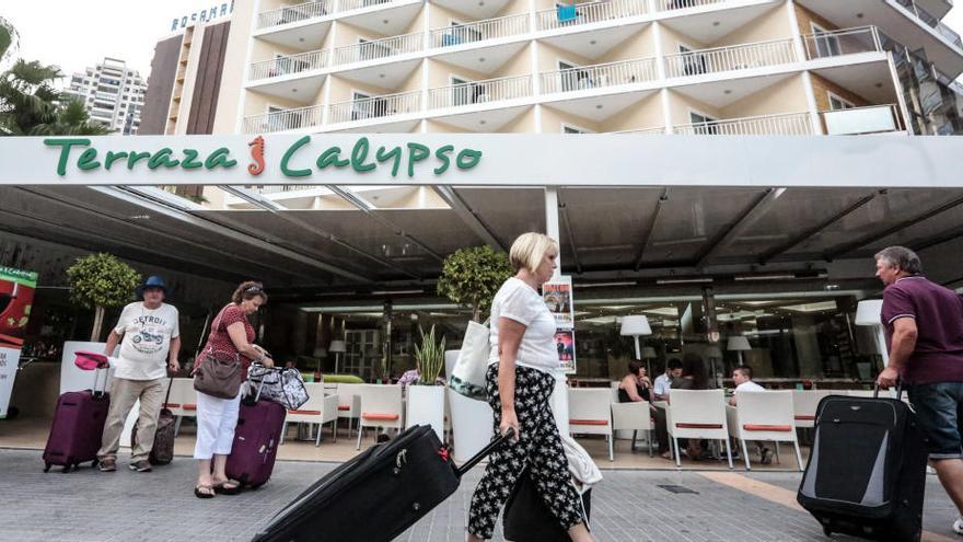 Turistas extranjeros, cargados con sus maletas, frente a un hotel de la ciudad.