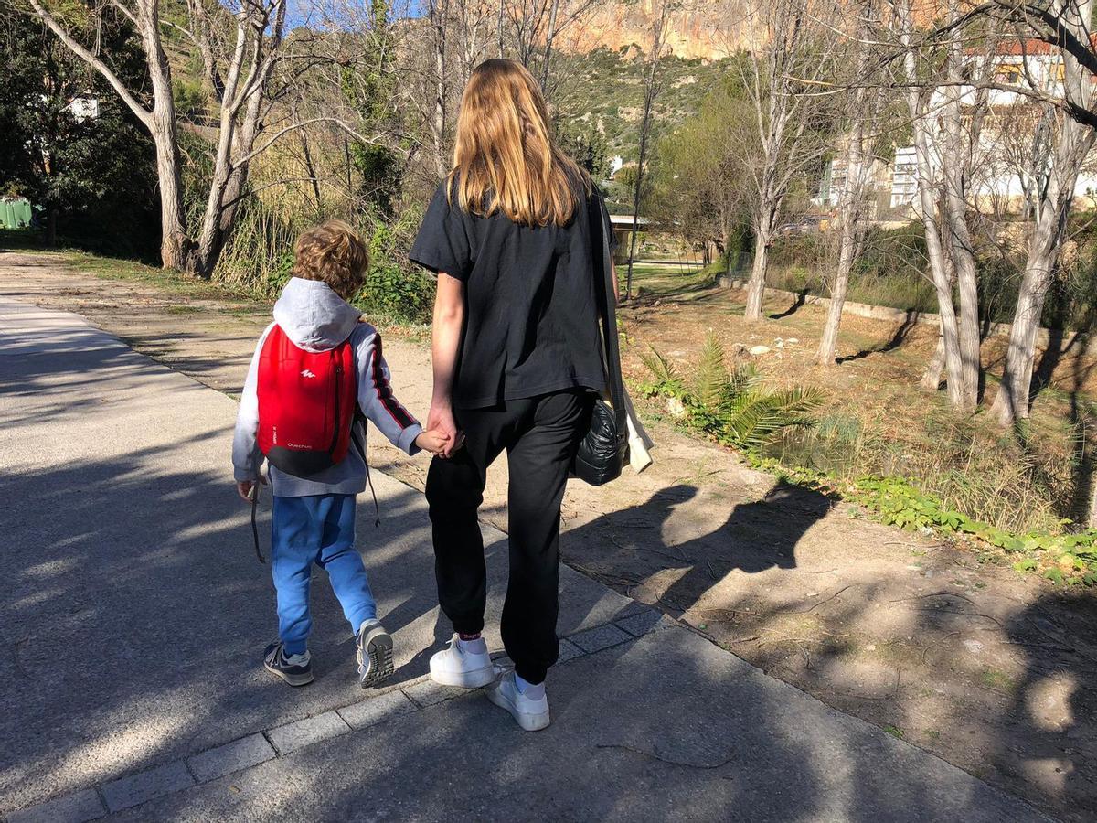 Carlos, paseando cogido de la mano de su madre, Cristina