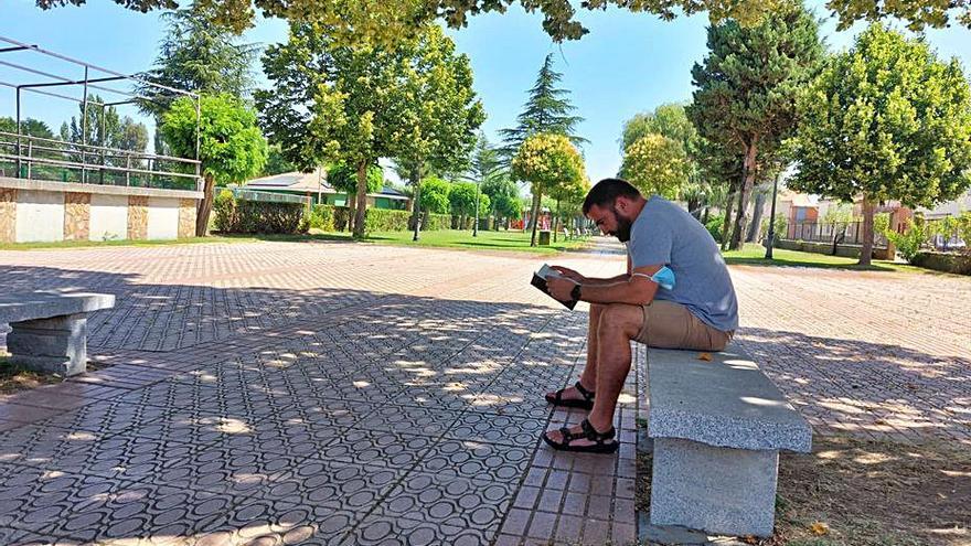 Un hombre leyendo un libro en el parque de Santa Croya de Tera | C. G. R.