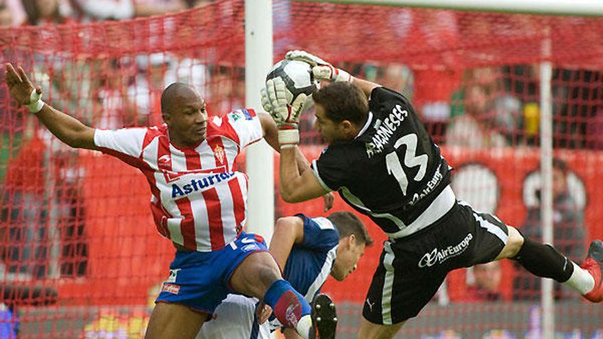 El portero del Tenerife, Sergio Aragoneses (d), bloca el balón ante el defensa francés del Sporting de Gijón, Gregory Arnolin, durante el partido, correspondiente a la trigésimo segunda jornada de Liga, que juegan los dos equipos, esta tarde, en el estadio de El Molinón, en Gijón.