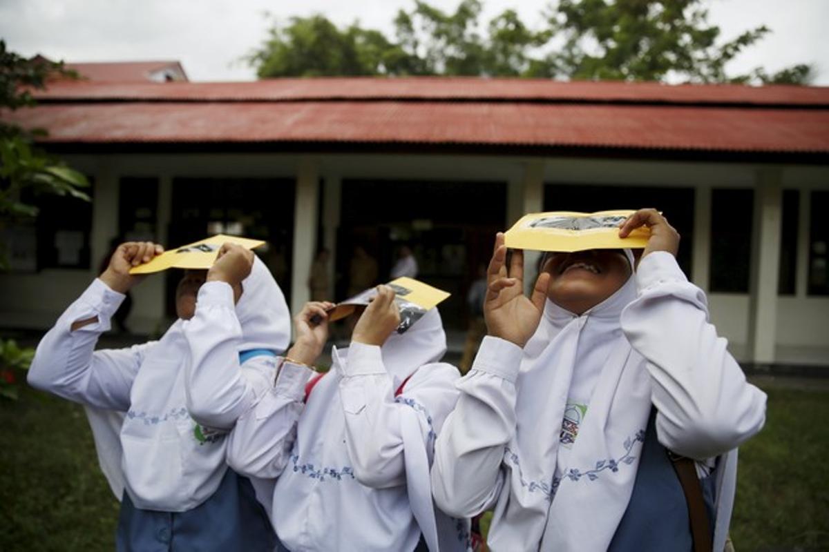 Students test their self-made filters and look at the sun after a joint workshop between the Hong Kong Astronomical Society and Indonesia’s National Institute of Aeronautics and Space (LAPAN) at a high school in Ternate island, Indonesia, ahead of Wednesday’s solar eclipse, March 7, 2016.  REUTERS/Beawiharta