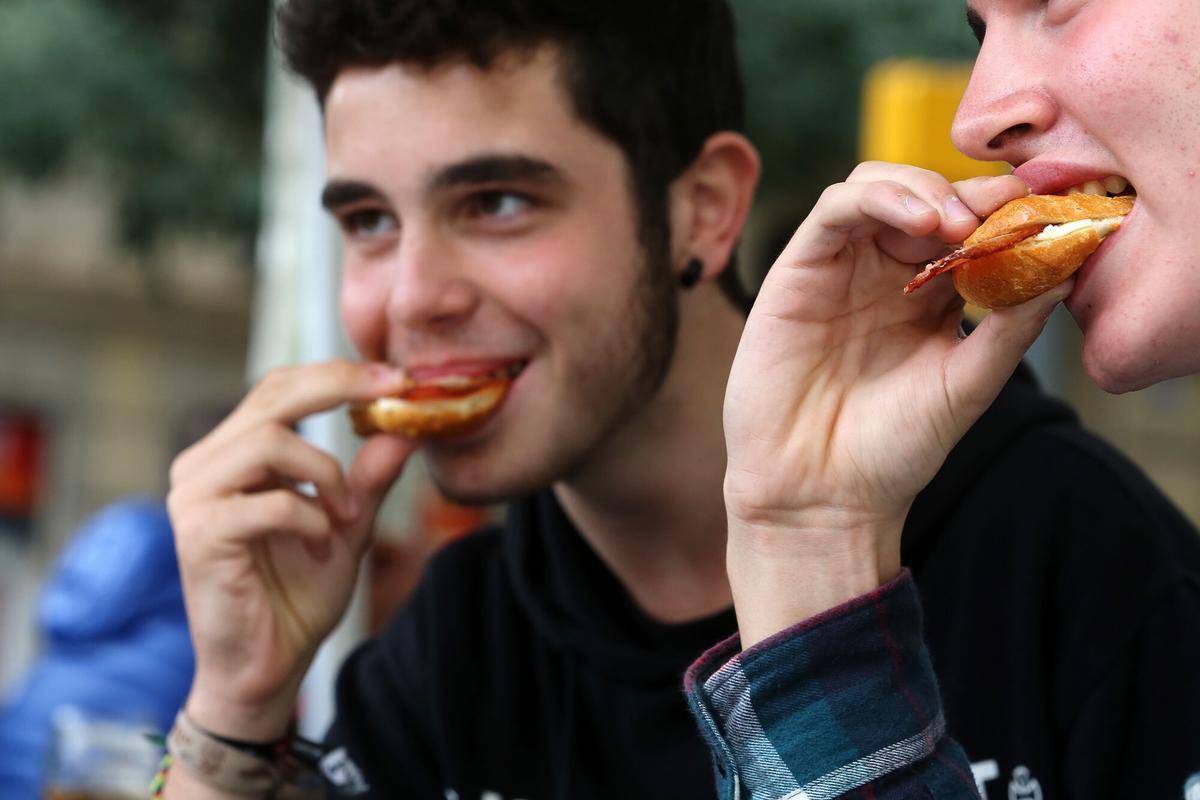 Dos personas comiendo un bocadillo.