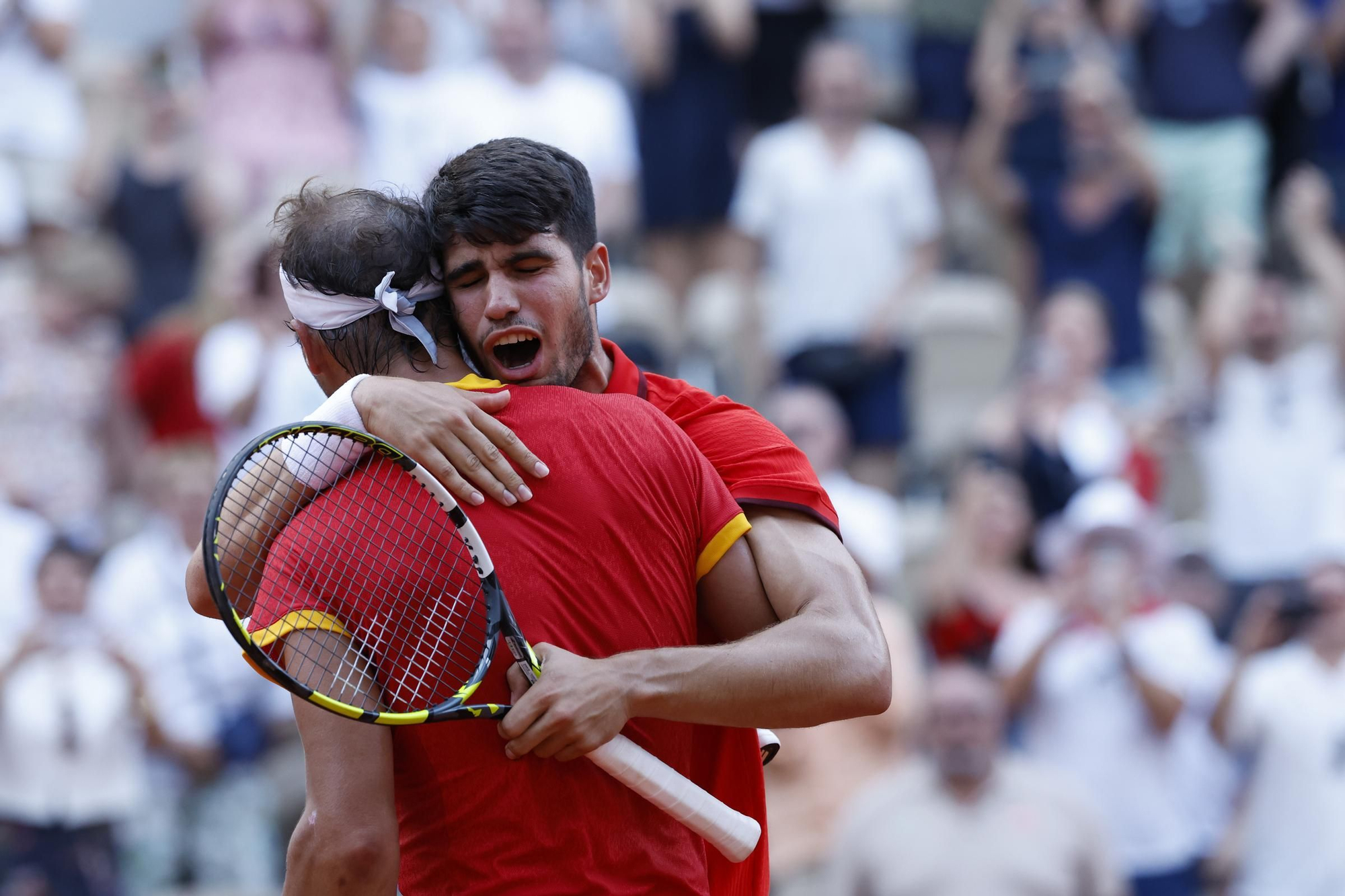 Rafa Nadal y Carlos Alcaraz se abrazan tras su victoria en octavos de final de París 2024.