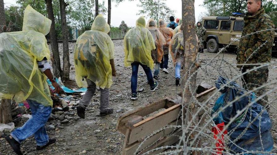 Refugiados entran bajo una fuerte lluvia en Macedonia.