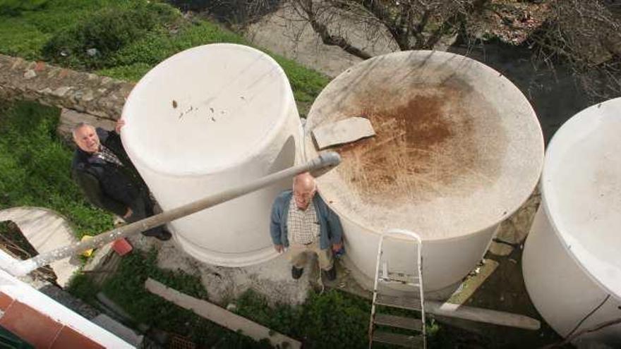 José Martín y un vecino en los Montes de Málaga junto a depósitos de agua potable para las casas.