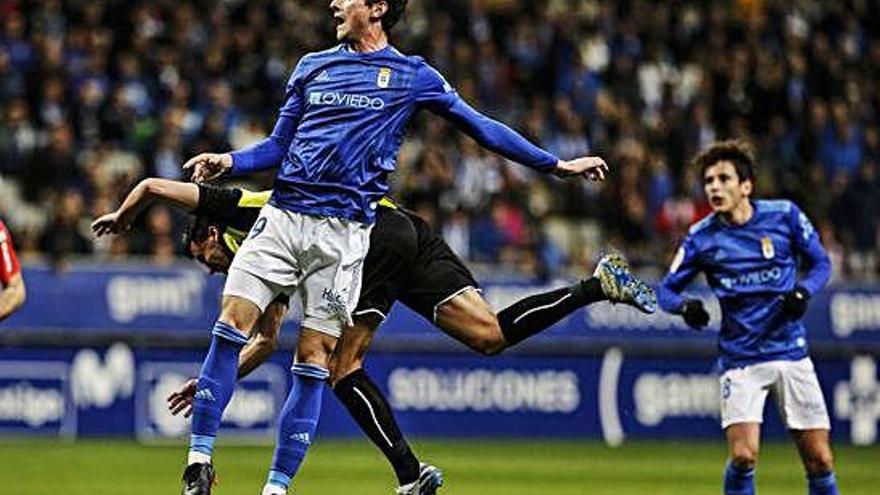 Un jugador del Oviedo choca contra un defensa del Tenerife ayer en el Tartiere.